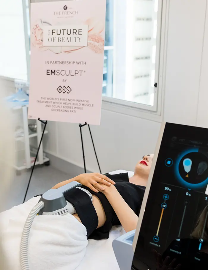 Image of a student laying on a treatment bed at The French Beauty Academy receiving a body contouring treatment EmSculpt